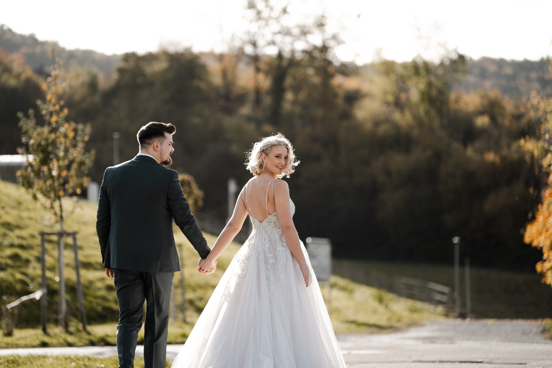 Brautpaar Hand in Hand im goldenen Abendlicht — Hochzeit Achtwerk Events